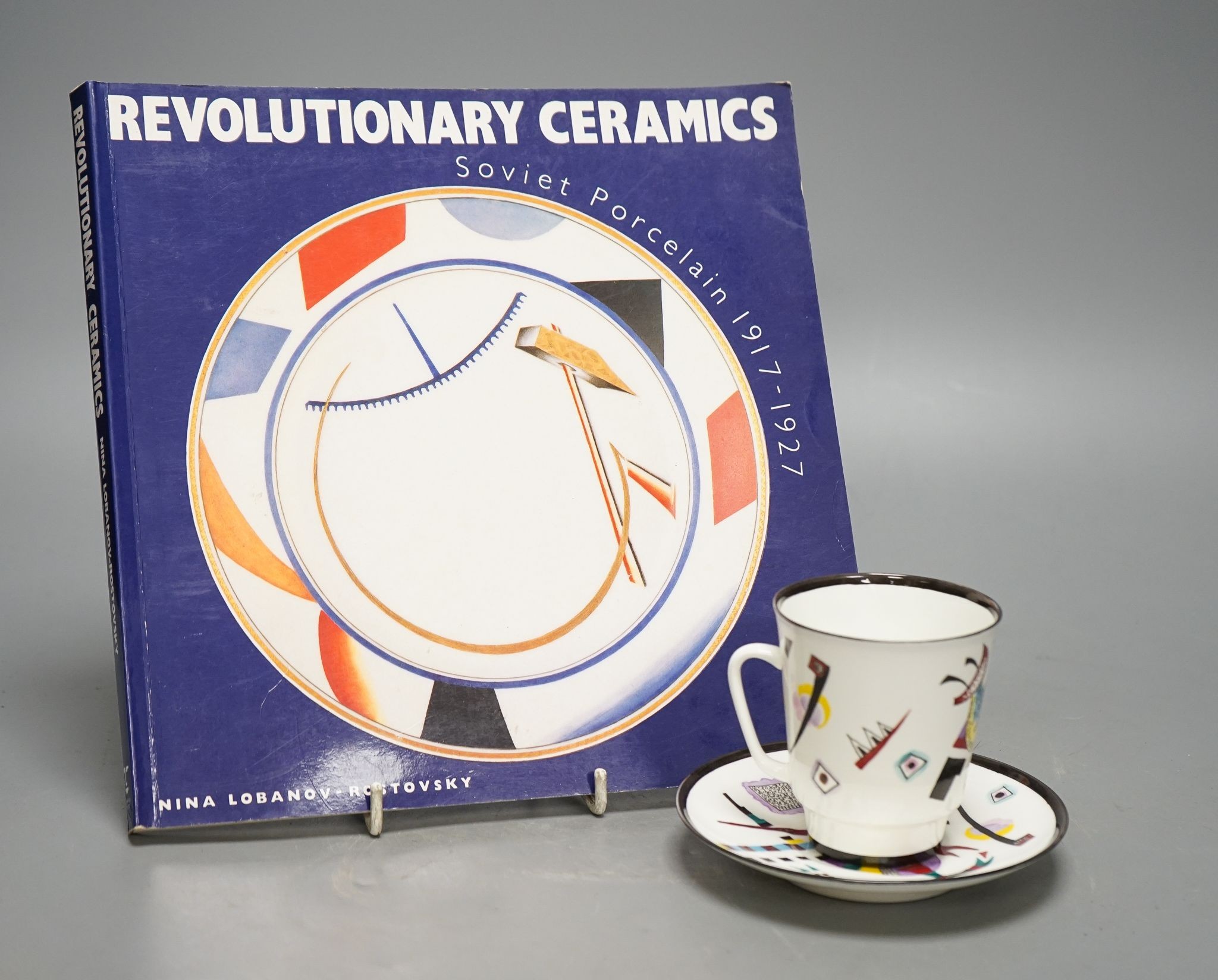 Russian Suprematist-style coffee cup and saucer, 20th century, together with a volume of Revolutionary Ceramics by Nina Lobanov-Rostovsky